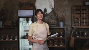 Shopkeeper taking notes and smiling in slow motion - Powered by Shutterstock - Get 15% off with code: PIKWIZARD15