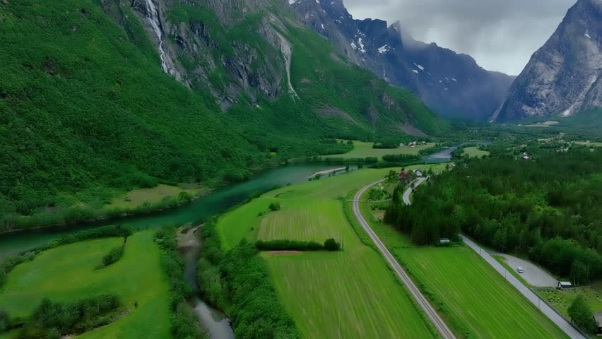 Aerial of the Rauma river winding through meadows and farmland in the Romsdalen Valley in Norway.