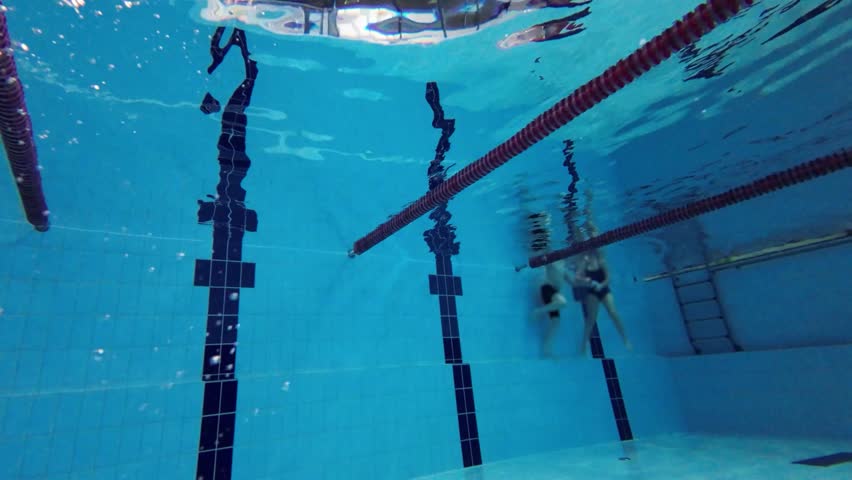 Swimmer girl dives into the water at the start in the pool.