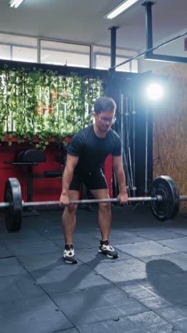 Man Performing Barbell Deadlift in Modern Gym