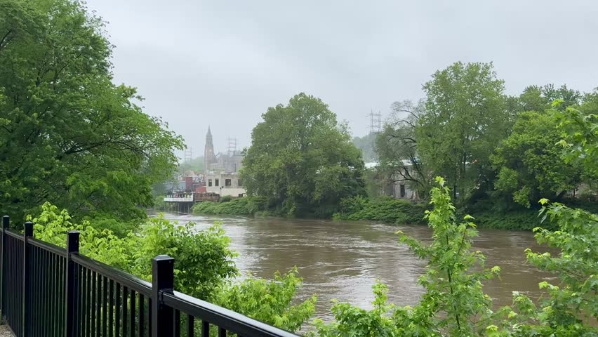 Muddy brown Schuylkill River flowing high and fast in front of Manayunk after heavy rainfall in Philadelphia, PA