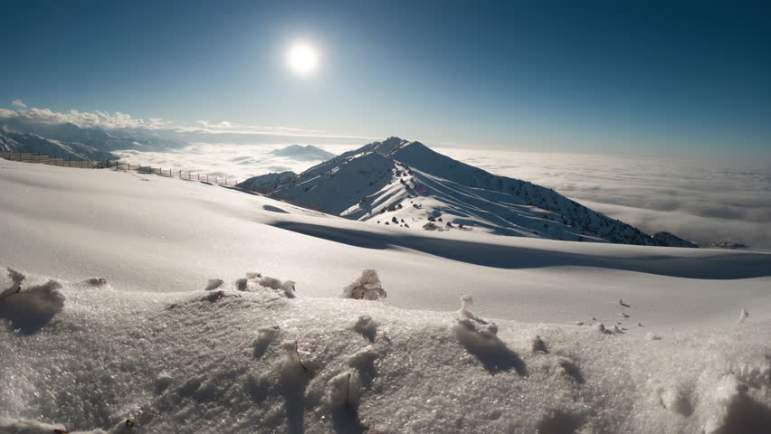Time Lapse High Mountains and Hills Valleys on a Winter Day . Cloudscape With White Puffy Clouds Moving and Snowed Mountain Picks on Light Sunny Winter Day Static Camera