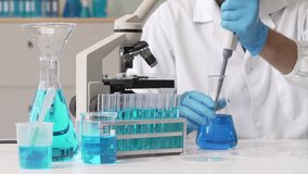 Young Caucasian male scientist works in laboratory, analyzing chemical samples with glassware and microscope. research tools, experiments, data interpretation, pharmaceutical development. - Powered by Shutterstock - Get 15% off with code: PIKWIZARD15