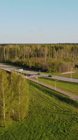 Aerial descend of suburban highway offramp and open roads on calm spring day