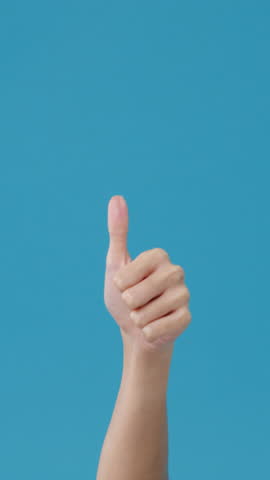 Vertical Screen : Young woman hand showing thumb up sign with fingers isolated over blue background in studio. Copy space for place a text, message for advertisement. Advertising area, mock up.