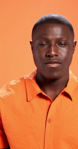 Hand, frame and face of black man in studio with smile in trendy clothes, style and outfit. Aesthetic, perspective and portrait of person with confidence, fashion and picture on orange background