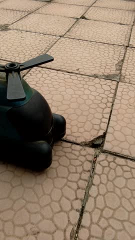 Vintage Metal Toy Helicopter With Propellers on a Paved Surface
