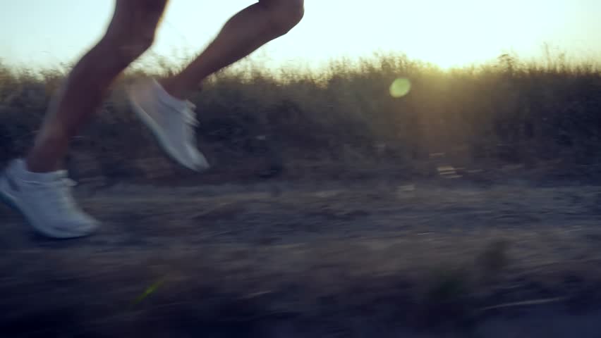 professional runner training high intensive interval. runner's legs in motion during early morning jog on a rural trail at sunrise. Fitness lifestyle concept, outdoor workout, healthy living