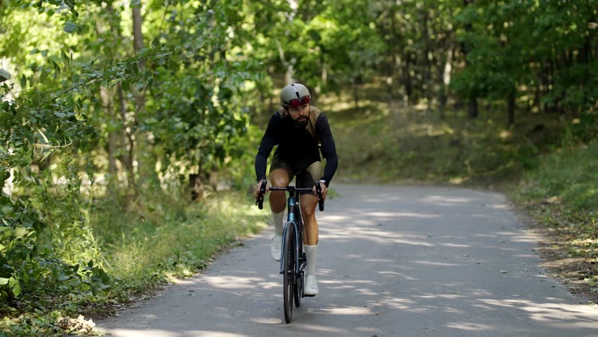Cyclists are cycling along a forest road. Cardio training cycling. Endurance cyclist cycling in nature. Morning ride on bike. Cyclist workout exercise. Training ride cycling. Outdoor sport cyclist