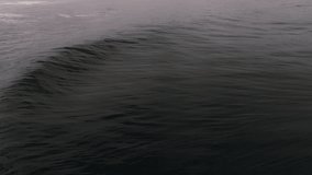 Slow motion wave forms smooth arc before crashing under overcast skies - Powered by Shutterstock - Get 15% off with code: PIKWIZARD15