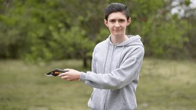 Teenage boy holding pruning shear in hands standing in front of garden. Adolescent boy with pruning shears, surrounded by garden backdrop. Young boy holding pair of garden scissors in garden setting - Powered by Shutterstock - Get 15% off with code: PIKWIZARD15