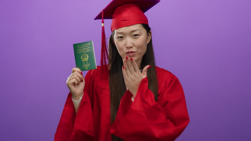 Woman in red graduation gown holding chinese passport against a purple background, symbolizing international education success and travel aspirations.