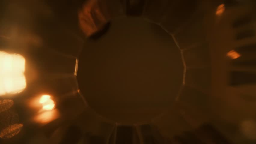 Creative inside-glass shot, ice cubes drop, alcohol pours, cola flows. Unique POV in warm orange-yellow tones. Cozy concept of home drinking