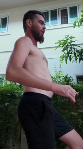 Overweight man examining belly after jumping workout