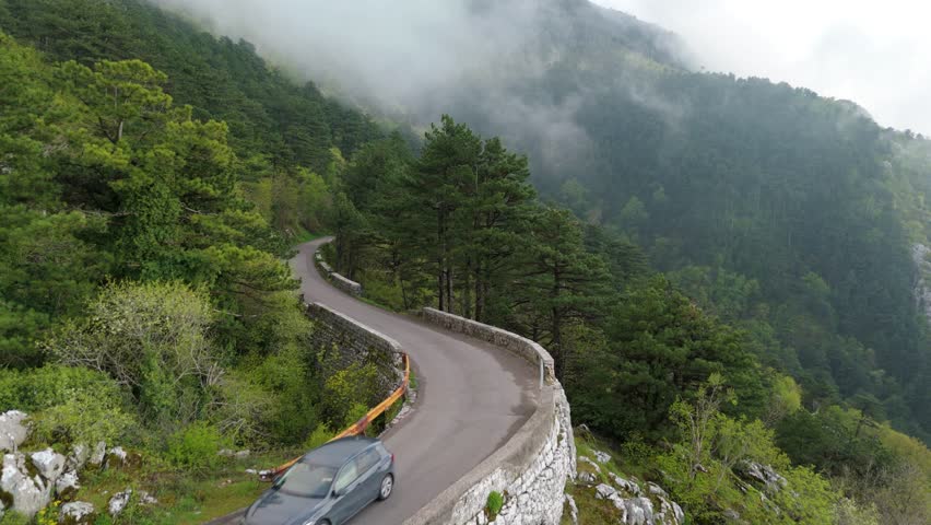Aerial drone view of Mountains and serpentine winding roads near Kotor Montenegro. Moody cloudy over summits and beautiful views into the valley UNESCO heritage Europe