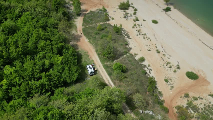 Aerial view of Buško lake in Bosnia and Herzegovina. Artificial lake with some motorhomes or campervans free camping on the beach.