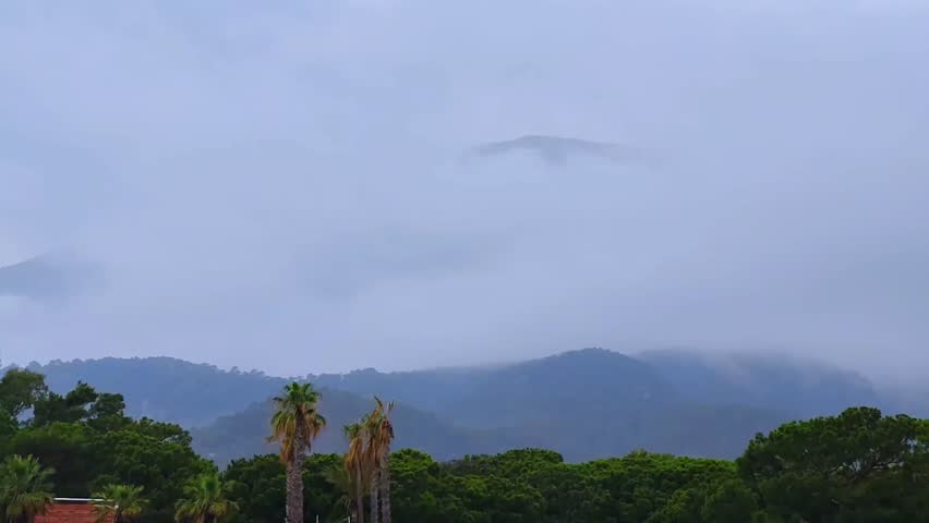 Heavy rains come. Beautiful mountains in the clouds. Storm clouds. Time lapse.