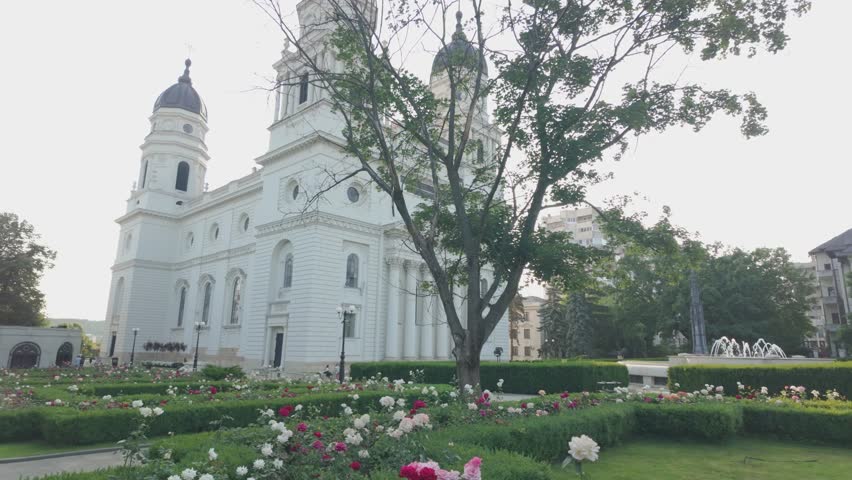 Catedrala Trei Ierarhi in Iasi at sunset, surrounded by a rose garden and fountain