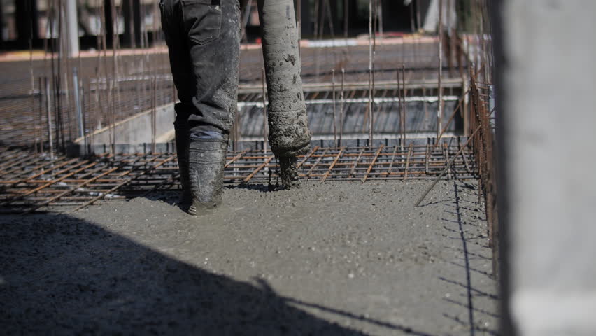 Concrete being poured onto rebar foundation at construction site