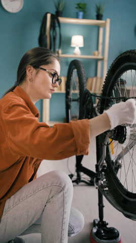 Home Bike Mechanic Woman Turning Pedals and Checking Wheel Function in Living Room