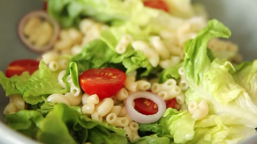 Pasta salad green leaf lettuce, tomato, pasta, onion fresh delicious gourmet food background on the table rustic food top view copy space keto and paleo diet vegan and vegetarian food