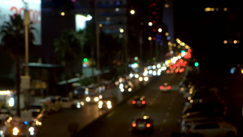 Blurred night city traffic with illuminated building and cars on road. Creating mesmerizing urban nightscape with dynamic light trails and vibrant metropolitan energy. Modern urban infrastructure.