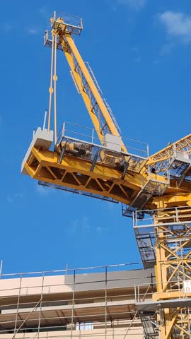 Tower crane or mobile crane erected beside under construction building.
Yellow color Building crane or Fixed crane used for lifting heavy items or materials from ground to top level for high building
