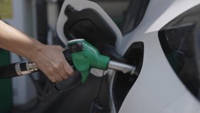Woman refueling her white car at a gas station - fuel and oil crisis concept - Powered by Shutterstock - Get 15% off with code: PIKWIZARD15