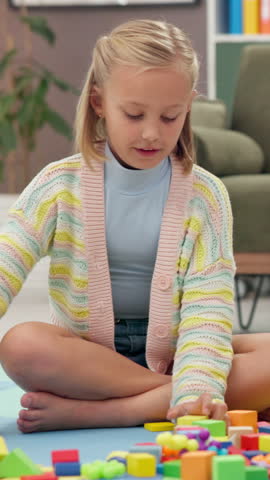 Building blocks, playing and kid in home for learning, creativity and fine motor skills on floor. House, girl and child with educational toys for game, hand eye coordination and cognitive development
