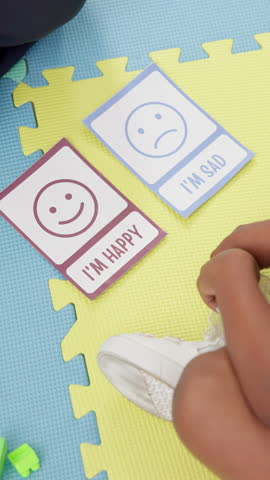 Child, therapy and cards for emotions, choice and counselling for help in office, hands and session. Above, therapist and consultation of kid with depression, people and appointment for mental health