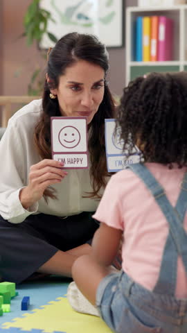 Woman, child therapist and card with choice for emotion, guide and test for wellness at clinic. Psychologist, girl and paper with happy, sad and assessment with emoji for mental health exam on floor