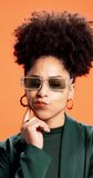 Thinking, sunglasses and woman in studio, decision and stylish outfit on orange background. Person, shades and model with choice, contemplation and problem solving with solution, wonder and planning - Powered by Shutterstock - Get 15% off with code: PIKWIZARD15