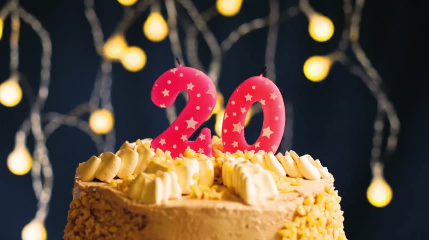 Celebrate turning 20 with a festive birthday cake featuring a pink number 20 candle. Captured in slow motion as the candle is blown out against a vibrant lighting backdrop.