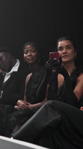 Crowd, gala and phone with woman at fashion show for runway event as clothing designer or stylist. Audience, entertainment and recording with happy person at launch or premiere of clothes brand