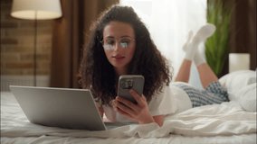 Woman in bedroom using laptop relax on bed Caucasian girl call mobile phone online shopping order delivery internet purchase at home smiling attractive female talk cellphone calling friend communicate - Powered by Shutterstock - Get 15% off with code: PIKWIZARD15