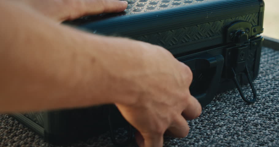Hands opening gun case with revolver resting inside on foam outdoors