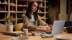 Caucasian woman small business owner saleswoman laptop working online sales ceramics craft store crockery handmade bowl female girl artist potter sculptor artist online shopping in pottery workshop - Powered by Shutterstock - Get 15% off with code: PIKWIZARD15