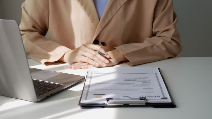 Young businesswoman holds a resume and evaluates it. Views the personal history of job applicants. Recruitment concept.