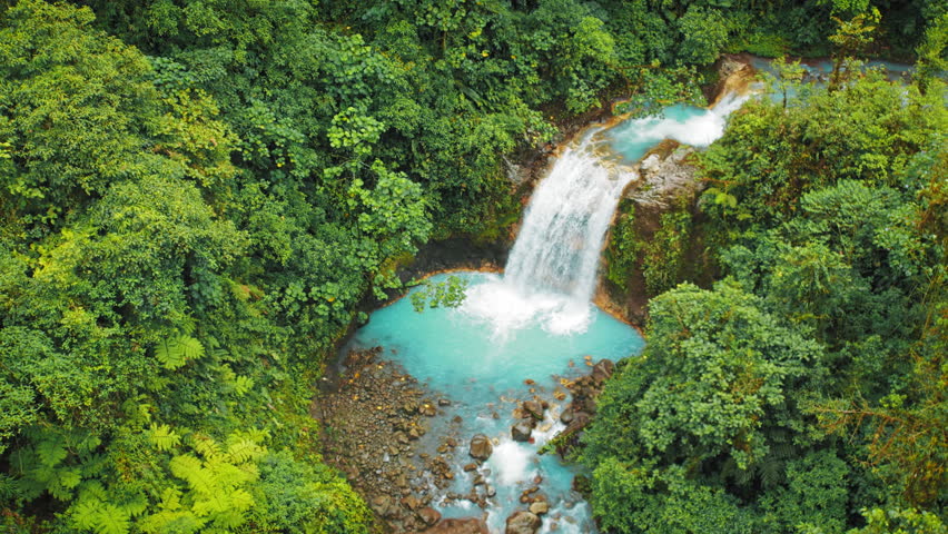 Unreal blue water of River and waterfall flowing in lush forest of Costa Rica