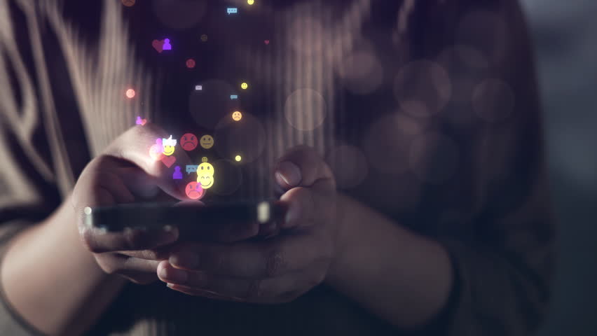 Close-up of hands holding smartphone with floating social media icons, symbolizing digital interaction, real-time communication, and online user engagement for modern technology and lifestyle themes.