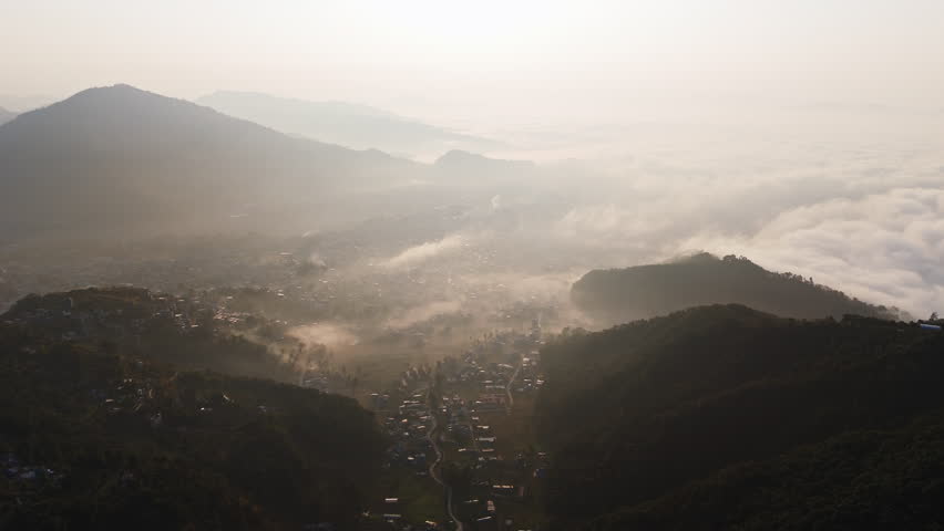 Panoramic drone shot of the mist covered Pokhara city and Phewa lake, in Nepal