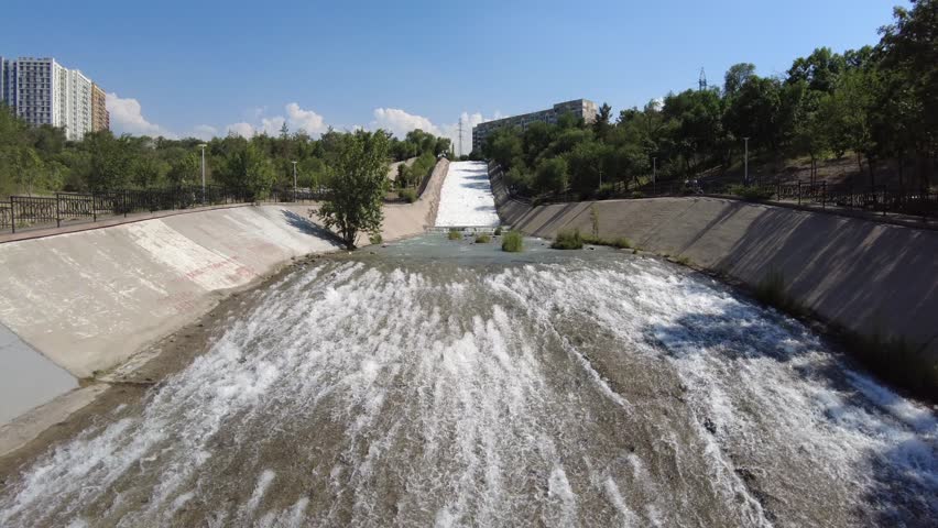 water flows through a concrete river channel in Almaty, Kazakhstan.