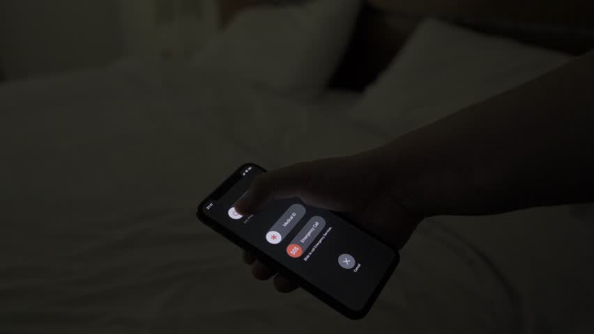 Turning off a smartphone and tossing it onto a bed, followed by lights turning off. Evening calm moment, disconnecting from technology for rest and relaxation.