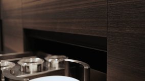 Close-up, female hand closing drawers of dark modern kitchen cabinets and showing dishes inside. Kitchen island, modern kitchen interior design. - Powered by Shutterstock - Get 15% off with code: PIKWIZARD15