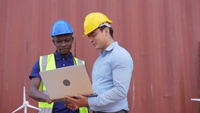 Engineer and African American worker discussing of solar energy from wind turbine model and laptop at construction site. diversity people brainstorming and working together - Powered by Shutterstock - Get 15% off with code: PIKWIZARD15