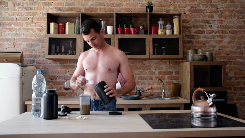 Young Athlete Man Preparing A Protein Shake In The Kitchen, Concept Of Sport Food Supplements For Fitness And Bodybuilding