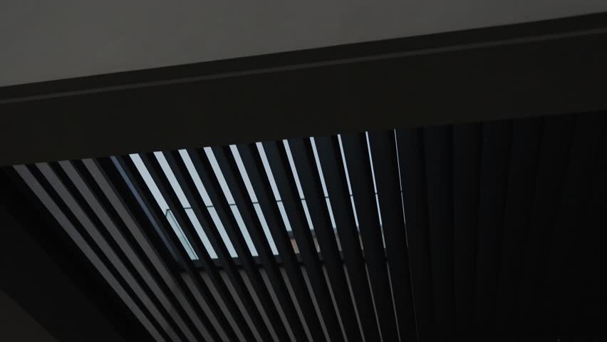 Black slatted roof. Slow motion. Modern architectural design of the house. Terraced roof against the backdrop of pine trees, combining beautiful views of nature.