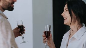 A happy couple clinks champagne glasses and shares a kiss in their freshly bought apartment, celebrating their first milestone as homeowner - Powered by Shutterstock - Get 15% off with code: PIKWIZARD15