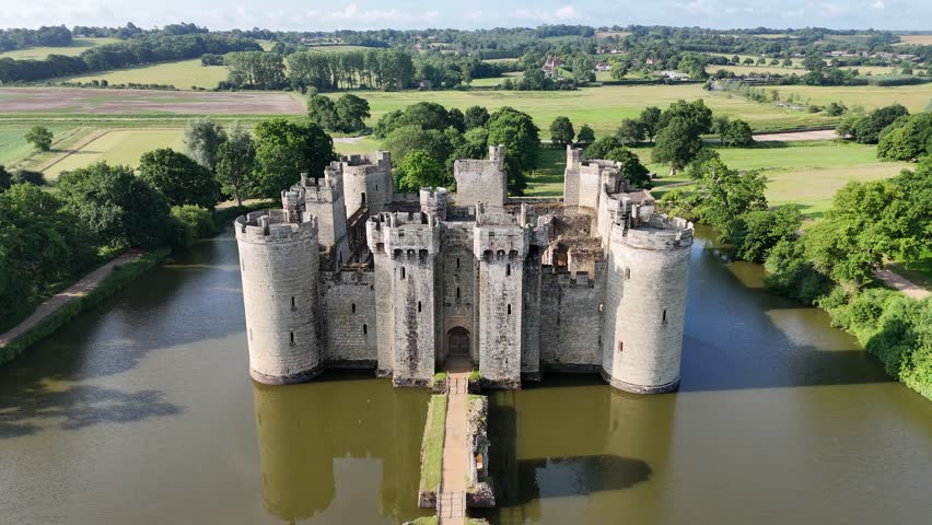Incredible aerial drone footage of Bodiam Castle as the camera flies away from the front of castle, offering a dramatic, sweeping view. Ideal for cinematic, historical, and travel content.