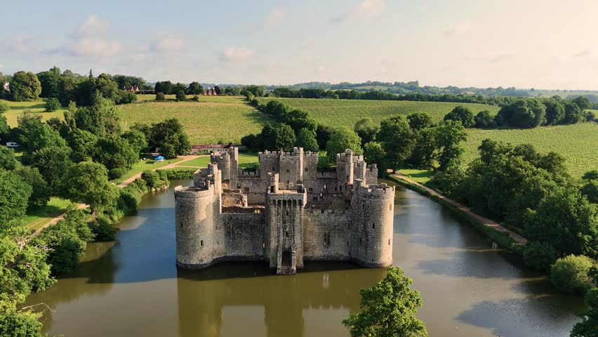Stunning aerial drone footage of Bodiam Castle as the camera flies away from rear of castle, offering a dramatic, sweeping view. Ideal for cinematic, historical, and travel content.